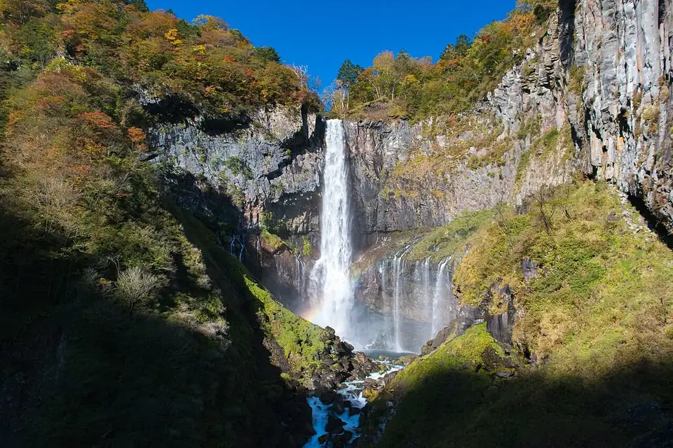 紅葉の始まった岩壁の間を一筋の滝が落ちる、日光の華厳滝